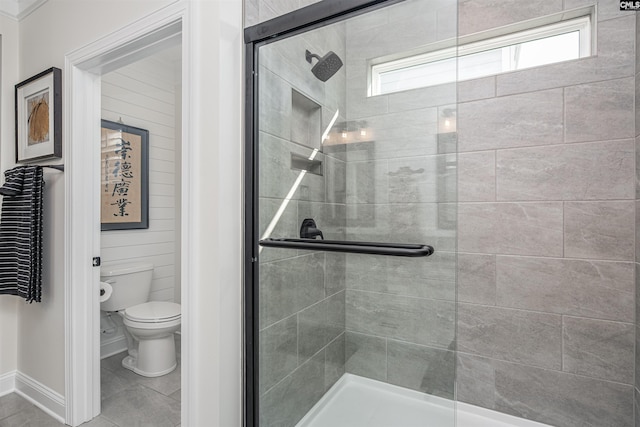 full bath featuring baseboards, tile patterned floors, a stall shower, and toilet