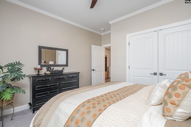 bedroom with a ceiling fan, crown molding, baseboards, a closet, and carpet flooring