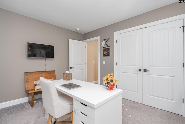 office area featuring light colored carpet and baseboards