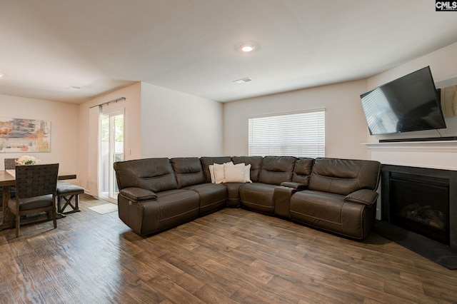 living area featuring recessed lighting, dark wood finished floors, visible vents, and a fireplace