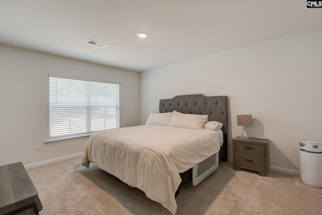 bedroom with visible vents, baseboards, and light colored carpet