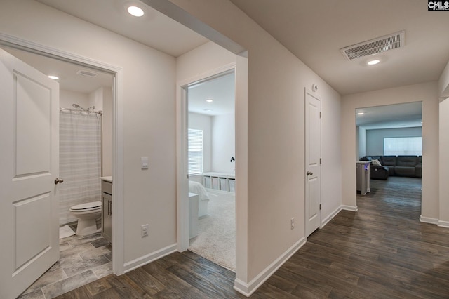 corridor featuring recessed lighting, baseboards, visible vents, and dark wood-style floors