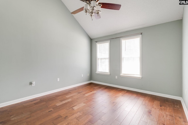 unfurnished room with baseboards, a ceiling fan, wood finished floors, and vaulted ceiling