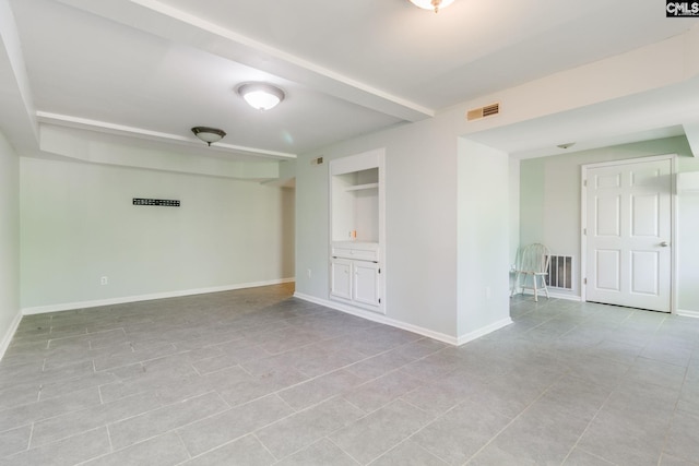 empty room featuring visible vents, baseboards, and light tile patterned floors