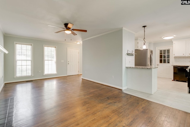 unfurnished living room with baseboards, ceiling fan, ornamental molding, and light wood-style flooring