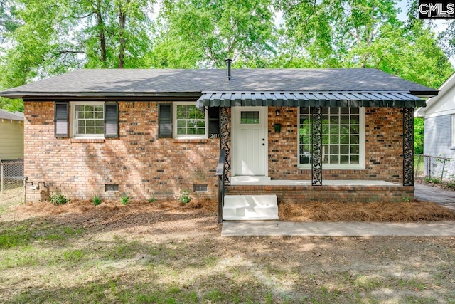 ranch-style house featuring fence, a shingled roof, and brick siding