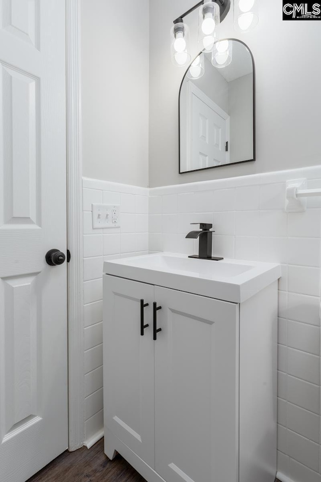 bathroom with wainscoting, tile walls, vanity, and wood finished floors