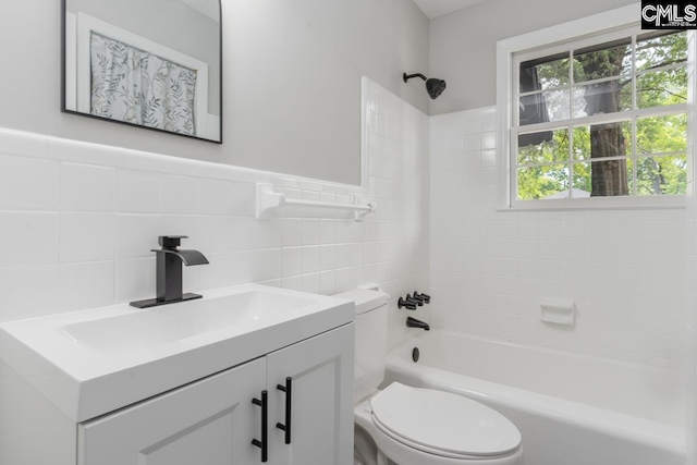 bathroom featuring toilet,  shower combination, tile walls, and vanity
