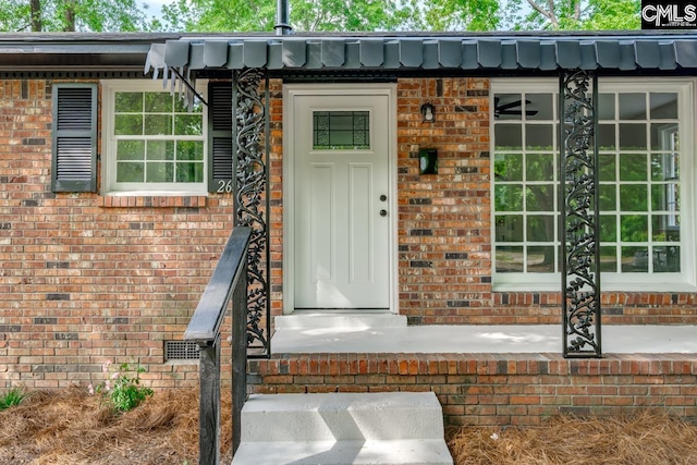 view of exterior entry with brick siding