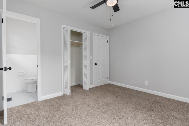 unfurnished bedroom with ceiling fan, baseboards, a closet, carpet, and ensuite bath