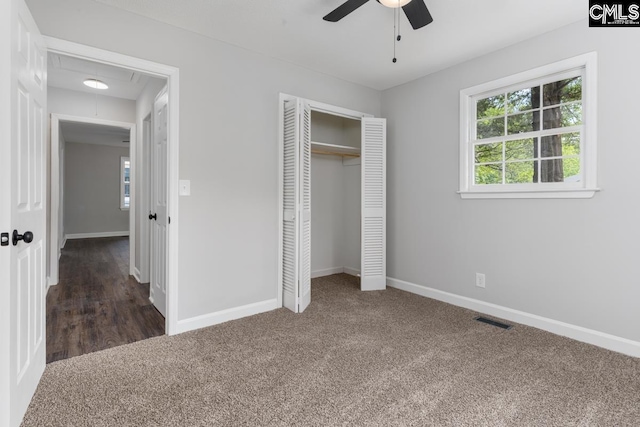 unfurnished bedroom featuring multiple windows, visible vents, carpet, and attic access