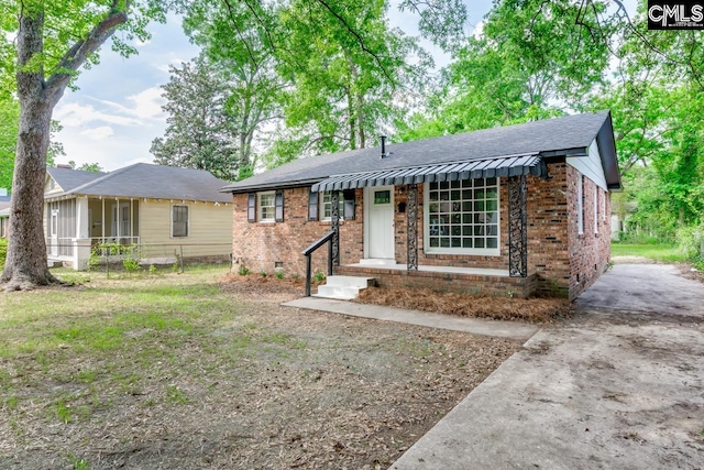 ranch-style home with brick siding and roof with shingles