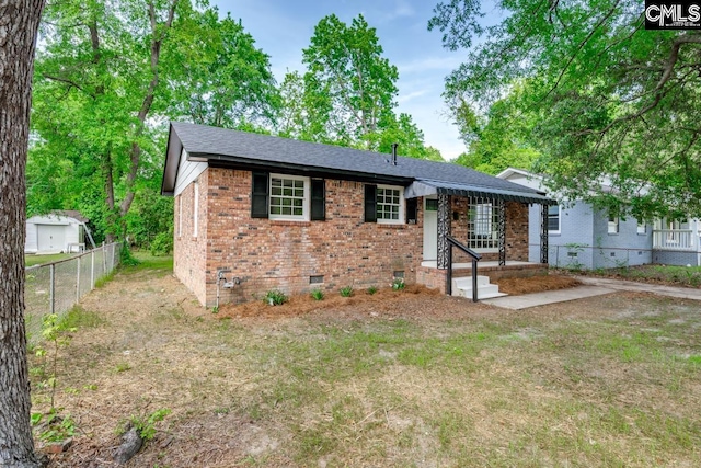 ranch-style home featuring brick siding, roof with shingles, fence, and crawl space
