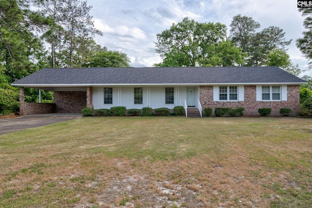 ranch-style house featuring roof with shingles, a front lawn, brick siding, aphalt driveway, and an attached carport