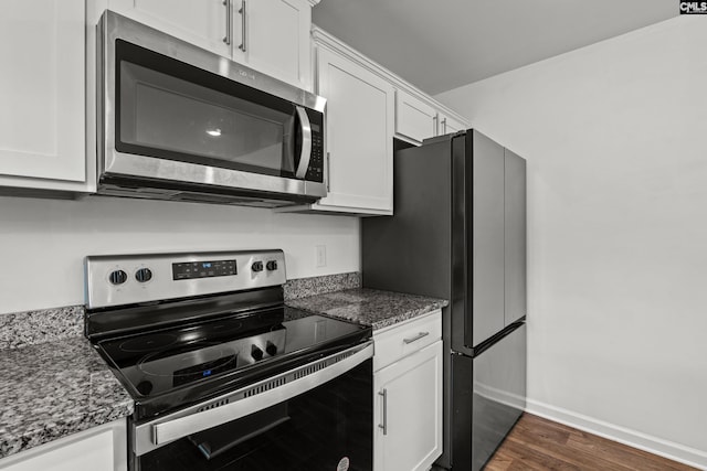 105 Maple Ct, Lugoff, SC 29073 - kitchen featuring appliances with stainless steel finishes, dark stone countertops, white cabinetry, baseboards, and dark wood-style floors