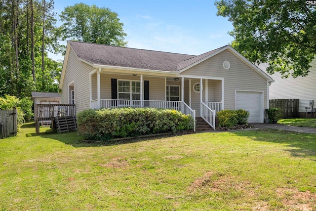 ranch-style house featuring a shingled roof, an attached garage, a porch, a front yard, and driveway