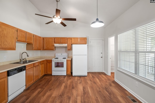 kitchen featuring visible vents, a sink, light countertops, under cabinet range hood, and white appliances