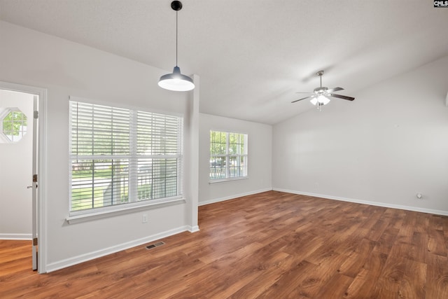 interior space with vaulted ceiling, baseboards, a ceiling fan, and wood finished floors
