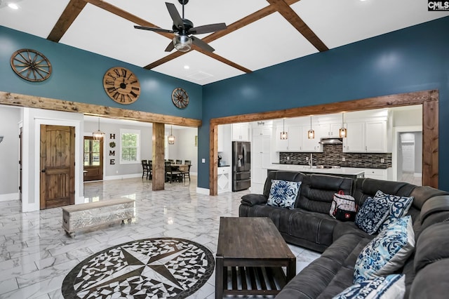 living area featuring ceiling fan, marble finish floor, recessed lighting, baseboards, and a towering ceiling