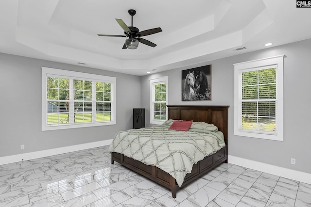 bedroom with a raised ceiling, marble finish floor, recessed lighting, baseboards, and visible vents