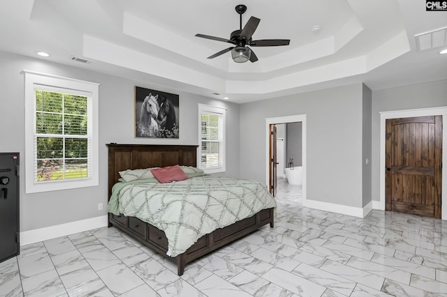 bedroom featuring a tray ceiling, visible vents, baseboards, and marble finish floor