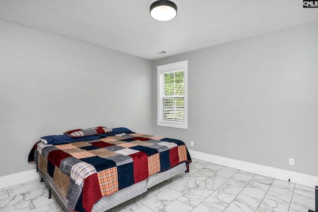 bedroom featuring baseboards and marble finish floor