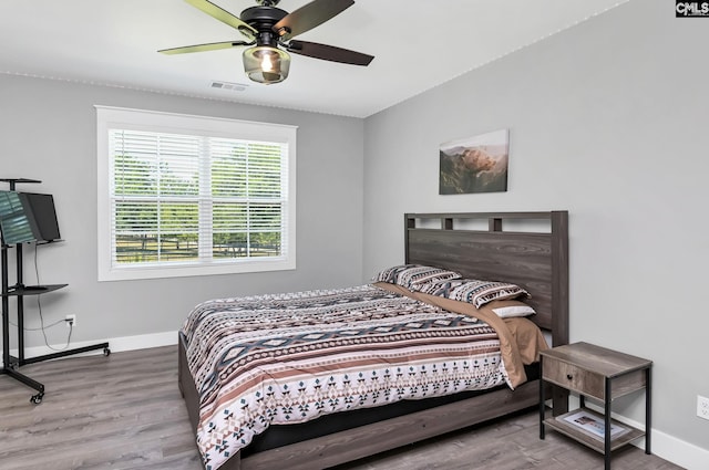 bedroom featuring ceiling fan, baseboards, visible vents, and wood finished floors