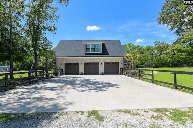 exterior space featuring concrete driveway, a lawn, fence, and a garage