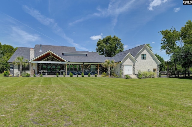 back of house with a lawn, a chimney, and stone siding