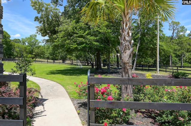 view of home's community with a lawn and fence