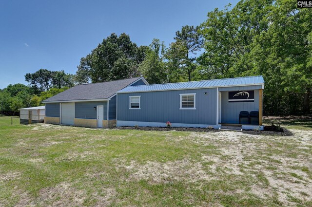 back of property with a lawn and metal roof