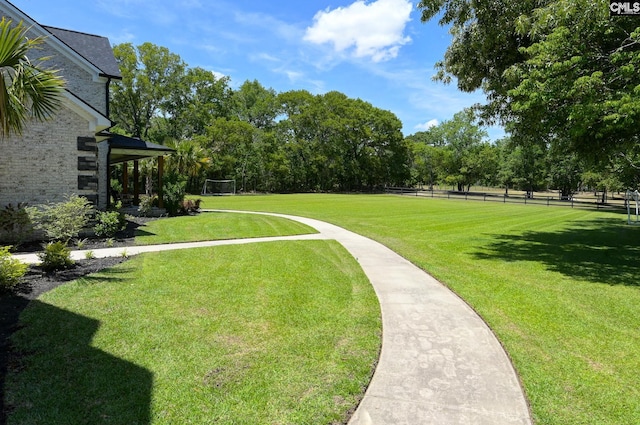 surrounding community with fence and a lawn