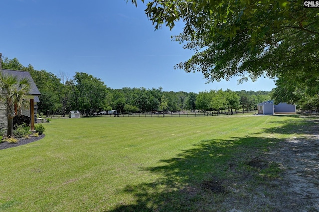 view of yard with a storage shed, fence, and an outdoor structure