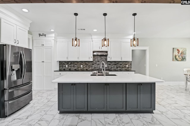kitchen with marble finish floor, stainless steel fridge, recessed lighting, white cabinets, and a sink