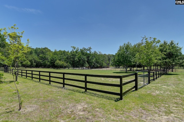 view of yard with fence and a rural view