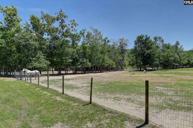 view of community featuring a lawn and fence