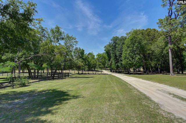 view of community with a yard and fence