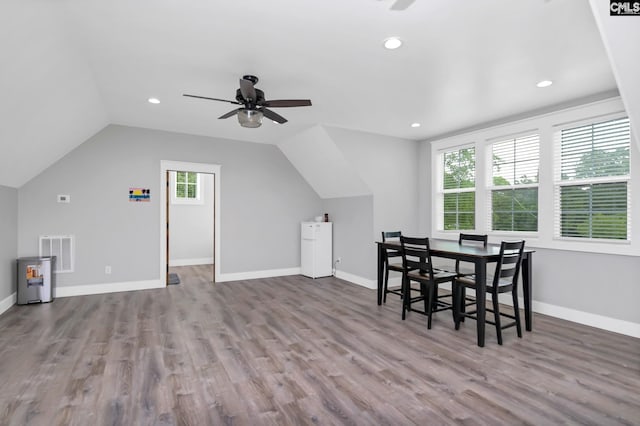 dining area with vaulted ceiling, a ceiling fan, visible vents, and wood finished floors