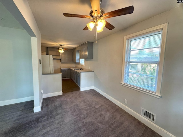 kitchen featuring visible vents, freestanding refrigerator, baseboards, and ceiling fan