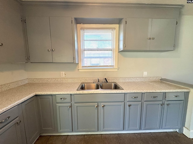 kitchen with a sink, light countertops, and gray cabinetry