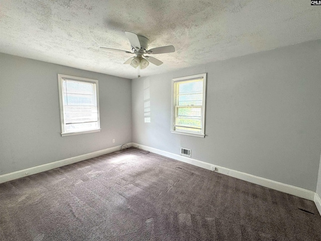 carpeted empty room with baseboards, a ceiling fan, a textured ceiling, and a healthy amount of sunlight