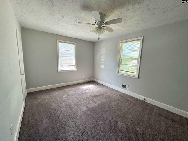 carpeted empty room featuring a ceiling fan, a textured ceiling, visible vents, and baseboards