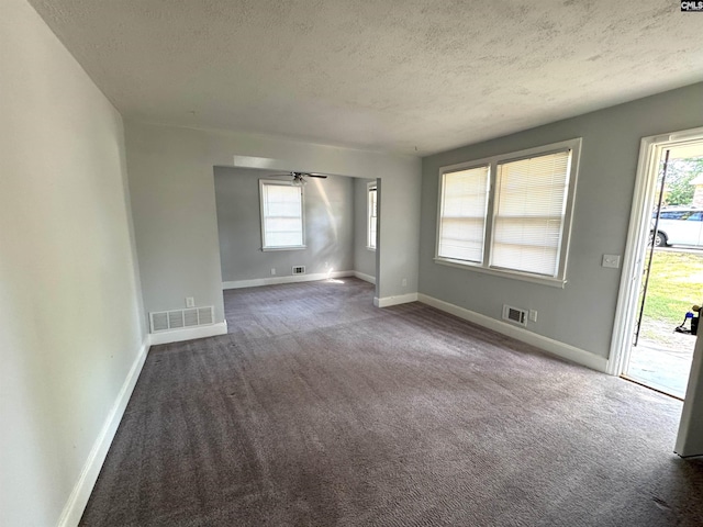 spare room featuring visible vents, carpet flooring, a textured ceiling, and ceiling fan