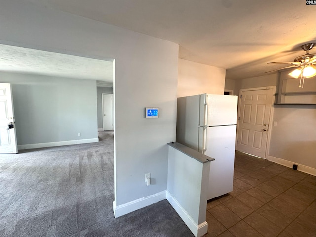 kitchen with freestanding refrigerator, a ceiling fan, and baseboards