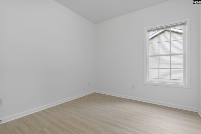 empty room with baseboards and light wood-type flooring