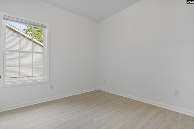 spare room featuring light wood-style floors and baseboards