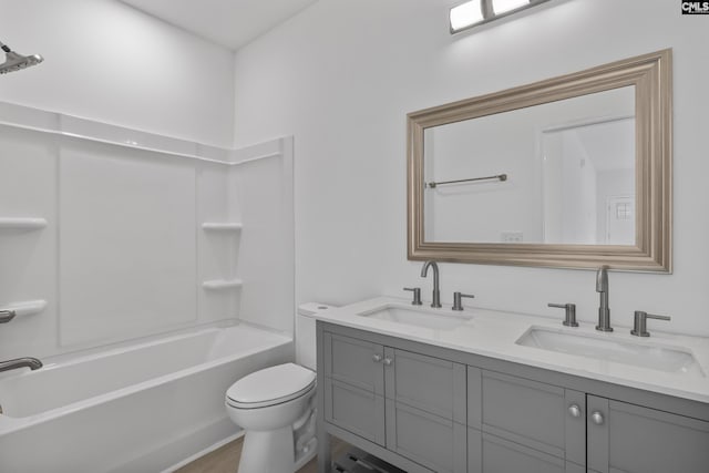 bathroom with double vanity, toilet, shower / bath combination, and a sink
