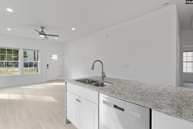 kitchen featuring a sink, a ceiling fan, dishwasher, and light stone countertops