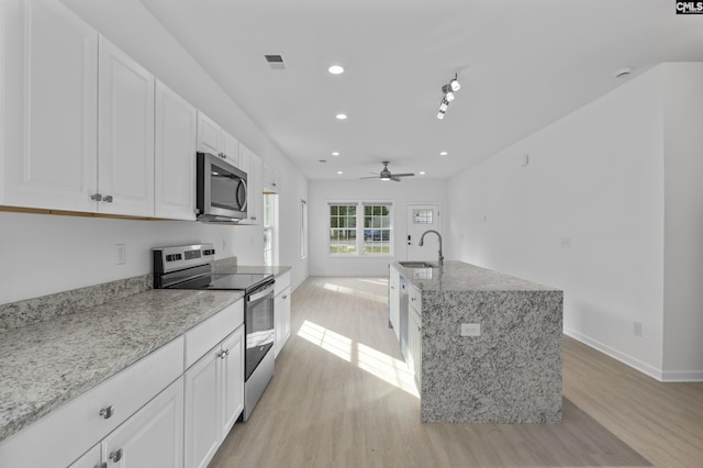 kitchen with a ceiling fan, light wood-style floors, recessed lighting, a sink, and stainless steel appliances