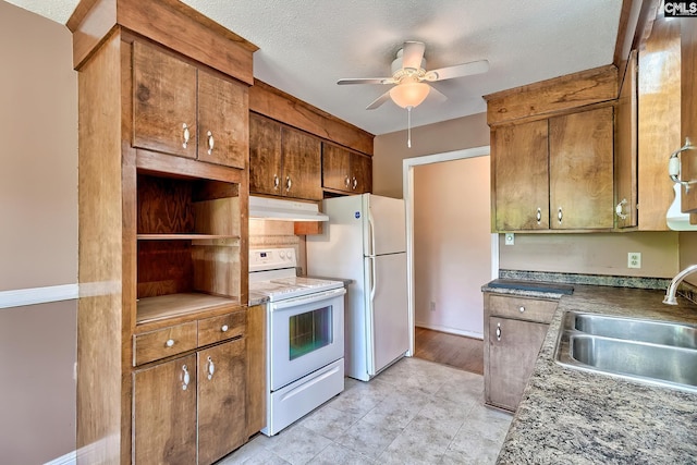 kitchen with a ceiling fan, white appliances, a textured ceiling, under cabinet range hood, and a sink
